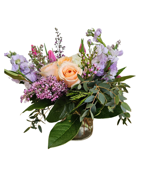 Clear cylinder vase with lavender stock, white hydrangea, peach roses, tulips, lush greenery, lavender accents