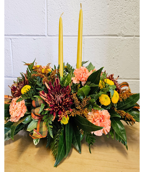 A Thanksgiving centerpiece with 2 tape candles and fall flowers